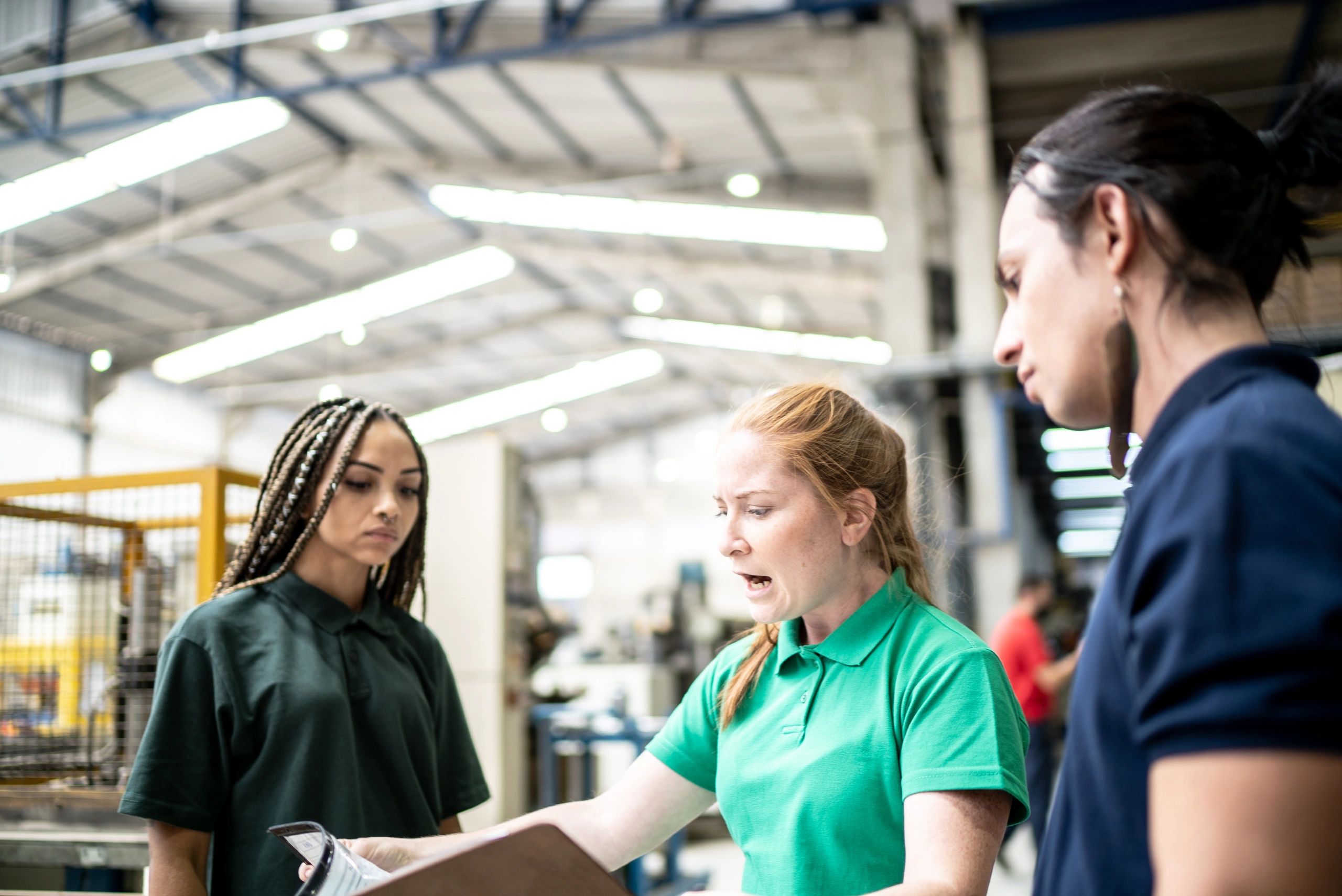 Inspector talking to production line workers in a factory