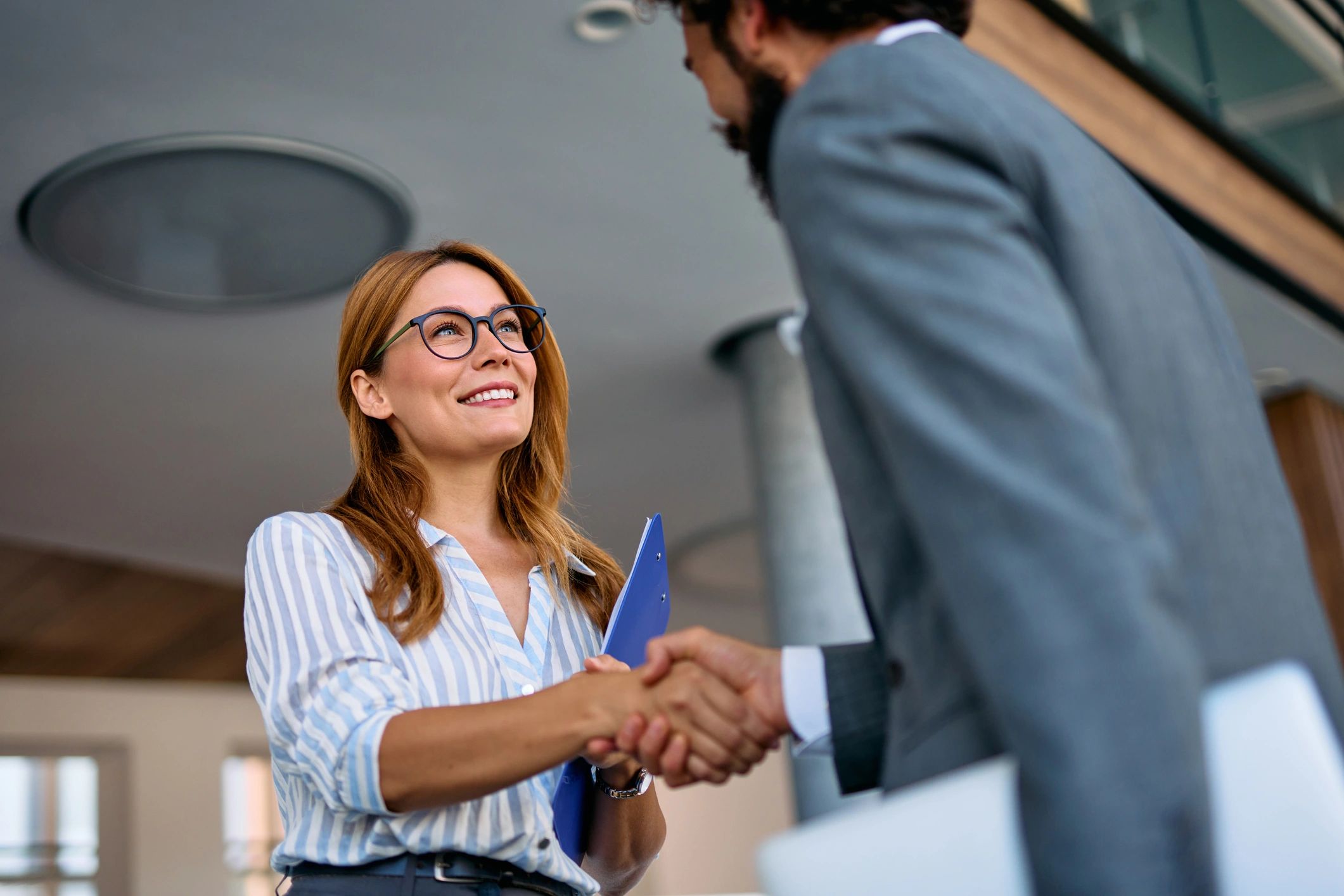 Businesswoman and businessman shaking hands in office