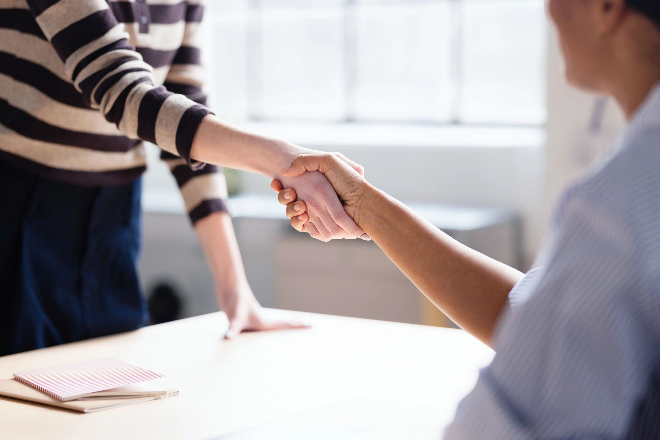 Two professionals shaking hands, representing trust and transparency